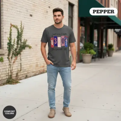 Young man wearing a pepper black Comfort Colors t-shirt featuring the 03801 Portsmouth NH zip code hometown pride design on a city street