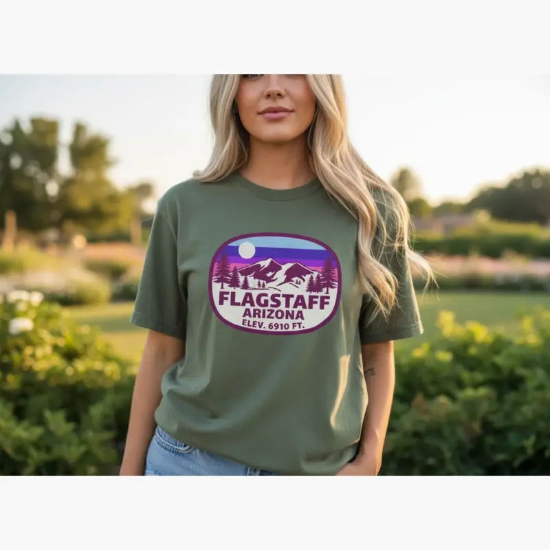 flagstaff-elevation-shirt-6910-ft-high-desert-hometown-tee-c-outdoor-natural-female-moss.webp Woman wearing moss green Comfort Colors t-shirt with 6910 ft Flagstaff Arizona elevation design in an outdoor high desert setting