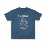Denim blue Comfort Colors garment-dyed t-shirt featuring a minimalist Flagstaff Arizona skyline illustration with the San Francisco Peaks and Route 66 corridor