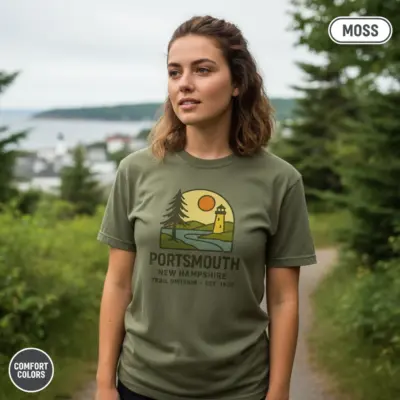 Woman wearing moss green Comfort Colors t-shirt featuring Portsmouth New Hampshire Est. 1623 heritage founding year design
