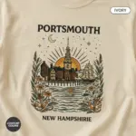 portsmouth-skyline-shirt-harbor-steeple-new-hampshire-tee-comfort-colors-t-shirt-closeup-detail-ivory.webp Ivory Comfort Colors t-shirt featuring a minimalist Portsmouth NH skyline illustration with harbor waterfront and colonial church steeples -- close-up detail view