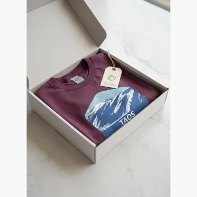 Berry garment-dyed Comfort Colors t-shirt featuring Taos Ski Valley New Mexico mountain ski graphic in product packaging